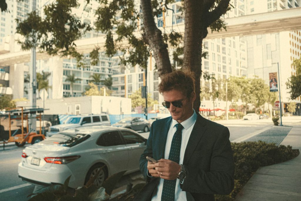 a man in a suit and tie looking at his cell phone
