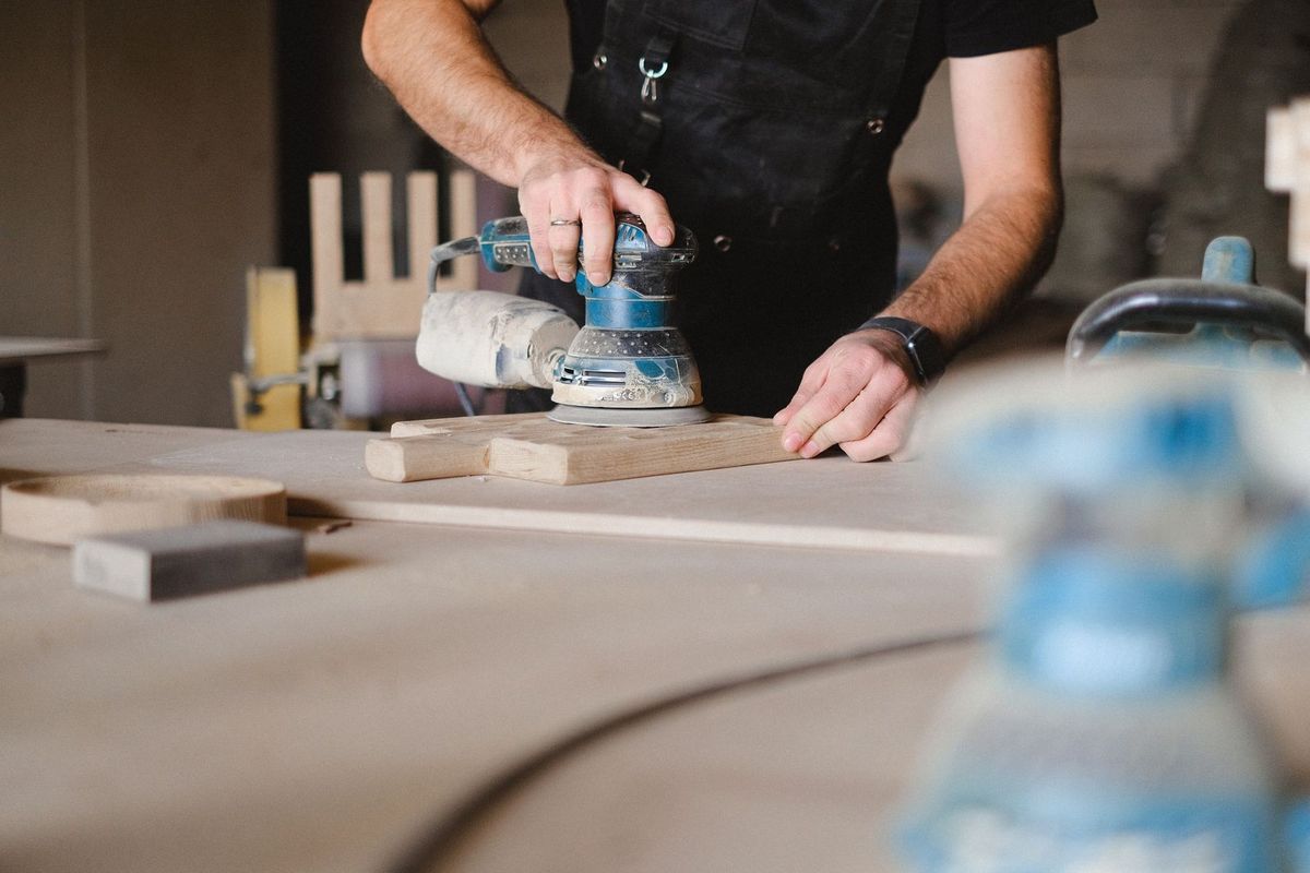 Homme utilisant une sabluse sur du bois dans un atelier