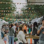 a crowd of people walking around a market