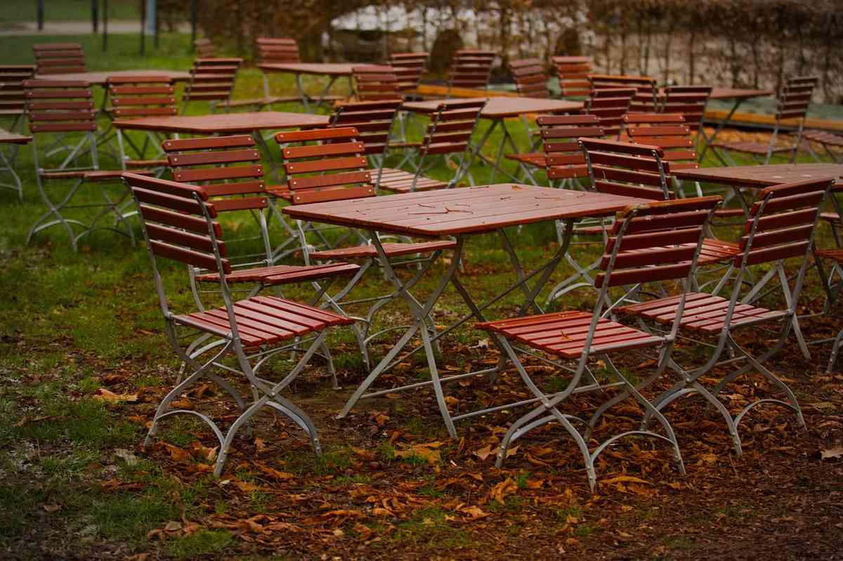 Tables et chaises de jardin, en rangées, sur un sol herbeux